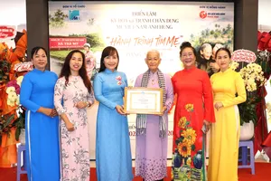 Bà Trịnh Thị Thanh, Phó Chủ tịch Thường trực Hội LHPN TPHCM, trao Bằng khen đến họa sĩ Đặng Ái Việt. Ảnh: THÁI PHƯƠNG