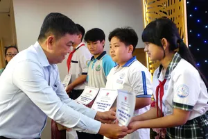 Trao học bổng đến trẻ mồ côi do dịch Covid-19. Ảnh: HỒNG HẢI