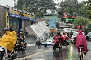 第十二郡东兴顺坊阮文过街一个招牌因强降雨而突然坠落。