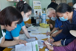 市社保机关工作人员指引民众登记以银行帐户领取退休金。