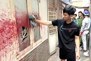 公安迫使泼漆者清理污渍。