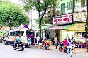 乘客在第五郡阮维阳街金孟雄车行代办处前等车。