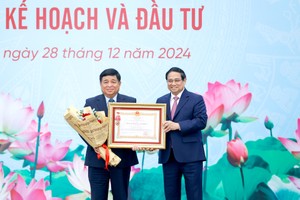 政府总理范明政向计划-投资部长阮志勇颁授一等劳动勋章。