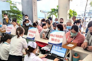 在嘉定人民医院就诊登记处，民众均严肃戴口罩预防疾病。