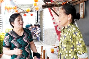 阮氏心党支书（左）探访街区里的民众。