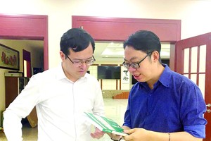 中国语文系副主任张家权博士向中国驻胡志明市总领馆副总领事徐州赠送《中国经济》一书。