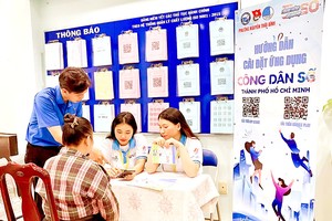 志愿者在第一郡阮太平坊人委会指引居民安装市数位公民应用程式。