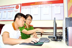 乡公安干部指引民众在国家公共服务网页办理行政手续。