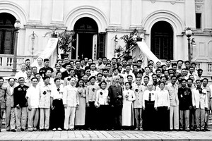 在1962年5月6日于主席府举办的第三次全国爱国竞赛英雄、战士联欢大会上，胡志明主席与获得表扬的各位代表留影。（资料图）