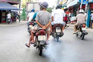 在街上行驶的摩托车正排放黑烟。