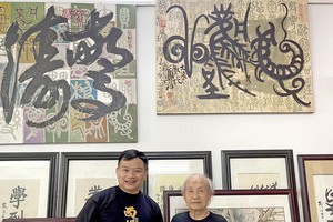 张路画家（右）向笔者赠送其写生集。