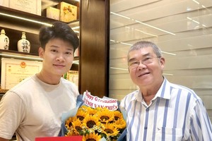 黄业新中医师（右）祝贺儿子万善取得一级专科证书。