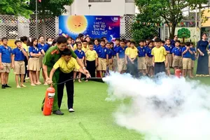 Cán bộ Cảnh sát PCCC và CNCH hướng dẫn học sinh sử dụng bình chữa cháy cầm tay dập tắt đám cháy