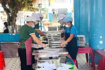 Nhân viên chuẩn bị bữa ăn cho học sinh Trường Tiểu học Lê Lợi, phường Tam Thắng. Ảnh: KHÁNH CHI.