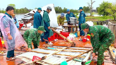 Cán bộ, chiến sĩ Đồn biên phòng Khánh Tiến cùng lực lượng Quân sự xã U Minh hỗ trợ hộ người dân che chắn lại nhà sau thiên tai. ẢNH: HOÀNG TÁ
