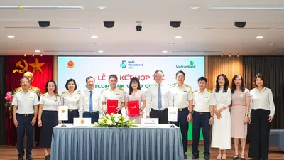 Ông Mai Sơn, Phó Cục Trưởng Cục Thuế (thứ 5, từ trái sang) và bà Đoàn Hồng Nhung, Giám đốc Khối Bán lẻ, Thành viên Ban điều hành Vietcombank (thứ 6, từ trái sang) thực hiện nghi thức ký kết và trao biên bản Thỏa thuận Hợp tác giữa Cục Thuế và Vietcombank dưới sự chứng kiến của đại diện lãnh đạo hai đơn vị