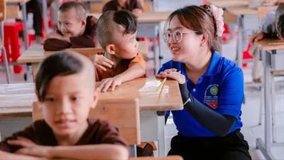 Giáo sinh trò chuyện với các em theo học miễn phí ở Trung tâm Nhân đạo Hồng Quang