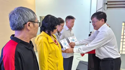 Người dân phường Trung Mỹ Tây, TPHCM nhận thẻ BHYT miễn phí theo Nghị quyết 56/2025/NQ-HĐND của HĐND TPHCM. ẢNH: MAI CHI