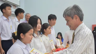 Ông Hồ Cảnh Hạnh, Phó Chủ tịch Hội Khuyến học TPHCM trao học bổng cho các em học sinh.