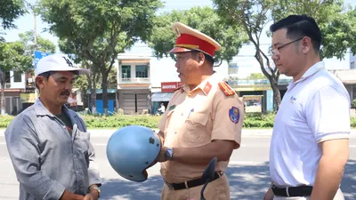 Thượng tá Phạm Hồng Hải, Phó Trưởng phòng CSGT tuyên truyền, tặng mũ bảo hiểm đạt chuẩn cho người dân