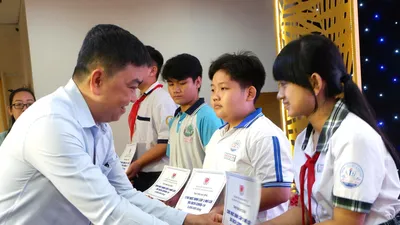 Trao học bổng đến trẻ mồ côi do dịch Covid-19. Ảnh: HỒNG HẢI