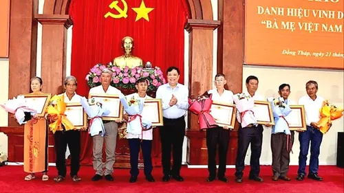 Đồng chí Phạm Thành Ngại, Chủ tịch UBND tỉnh Đồng Tháp, trao bằng công nhận và hoa cho thân nhân các Bà mẹ Việt Nam Anh hùng. Ảnh: VIỆT TIẾN