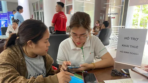 Nhân viên ngân hàng hỗ trợ hộ kinh doanh tại Cơ sở 3 Thuế TP Đồng Nai (phường Trấn Biên). Ảnh: PHÚ NGÂN