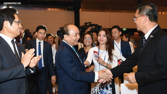 Prime Minister Nguyen Xuan Phuc talks with delegates attending the Conference in 2018.