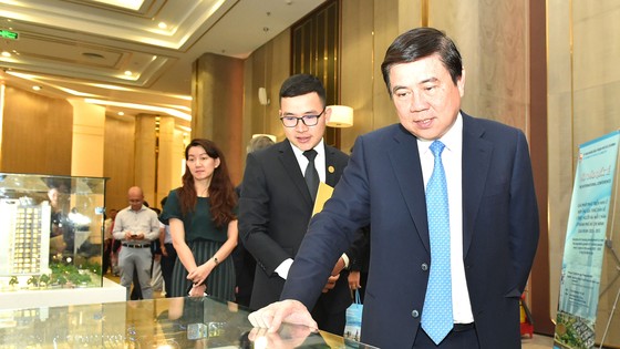 Chủ tịch UBND TPHCM Ngyễn Thành Phong xem một dự án địa ốc tại Hội thảo về nhà ở TPHCM. Ảnh: VIỆT DŨNG