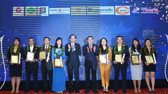 Phó Chủ tịch Thường trực UBND TPHCM Lê Thanh Liêm và Tổng Biên tập báo SGGP Nguyễn Tấn Phong trao giải thưởng Thương hiệu Vàng 2020 cho các doanh nghiệp. Ảnh: VIỆT DŨNG