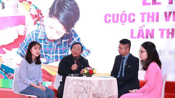 Nhà thơ Trần Đăng Khoa giao lưu với các em học sinh tại buổi lễ phát động. Ảnh VNP