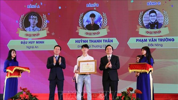Đồng chí Võ Văn Thưởng, Ủy viên Bộ Chính trị, Bí thư Trung ương Đảng, Trưởng Ban Tuyên giáo Trung ương cùng Bộ trưởng Bộ Giáo dục và Đào tạo Phùng Xuân Nhạ trao giải Nhất cho thí sinh đạt giải. Ảnh: TTXVN