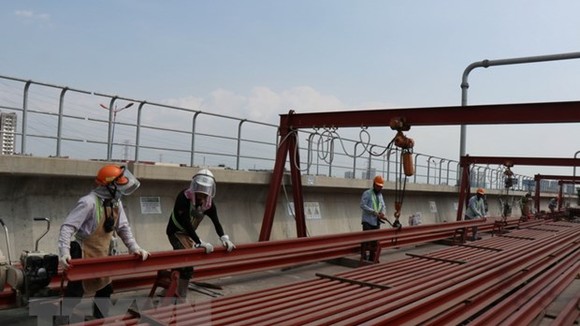 Công nhân thi công đường ray tuyến metro số 1 tại ga Phước Long. (Ảnh: Tiến Lực/TTXVN)