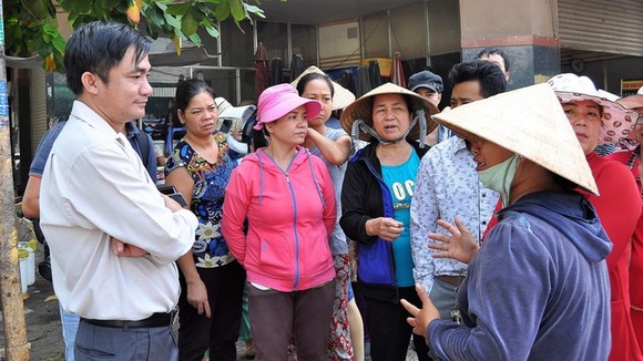 Ông Lê Thanh Bình (bìa trái) lúc còn là Phó Chủ tịch UBND quận Tân Bình đang lắng nghe ý kiến của tiểu thương chợ Tân Trụ (phường 15) khi quận xử lý lấn chiếm vỉa hè, lòng đường. Ảnh: KIỀU PHONG