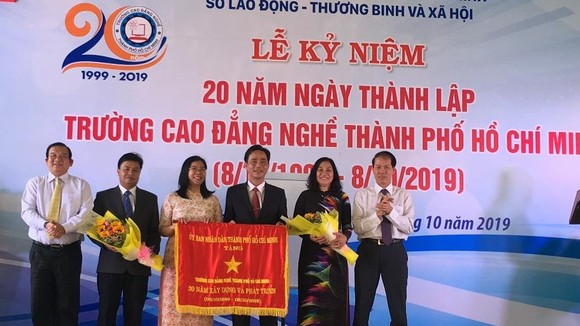 Ông Lê Minh Tấn, Giám đốc Sở LĐTB-XH TPHCM ( ngoài cùng bên trái) đại diện UBND TPHCM trao bức trướng của UBND TPHCM cho Ban Giám hiệu nhà trường