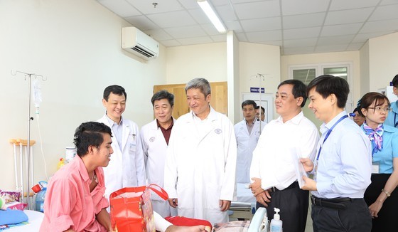 Deputy Health Minister Nguyen Truong Son pays a patient in Cho Ray Hospital a visit in the hospital (Photo: SGGP)