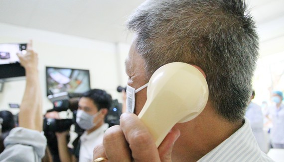 Deputy Minister of Health Nguyen Truong Son (L) communicates with Vietnamese American COVID-19 patient who is allowed to be discharged from the hospital (Photo: SGGP)