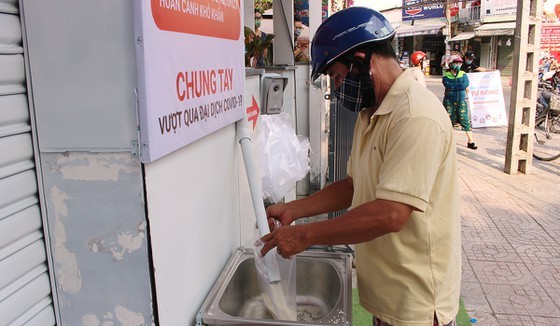 Poor people just press a button and the dispenser will provide rice. Each person receives 1.5 – 2 kg each time (Photo: SGGP)