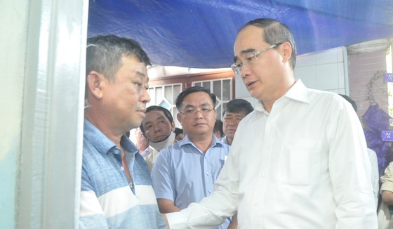 Secretary of the Ho Chi Minh City People’s Committee Nguyen Thien Nhan (1st, R) expresses his condolence to the bereaved father (Photo: SGGP)