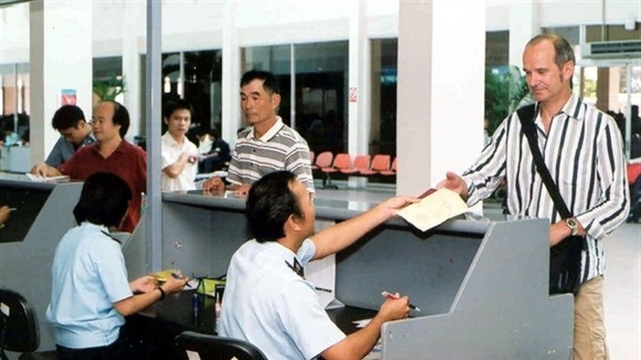 A customs official conducts immigration procedures for a foreigner at Tan Son Nhat airport in HCM City. — VNA/VNS Photo