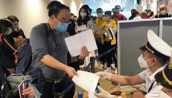 People from oversea write mandatory health declarations at Tan Son Nhat Airport (Photo: SGGP)