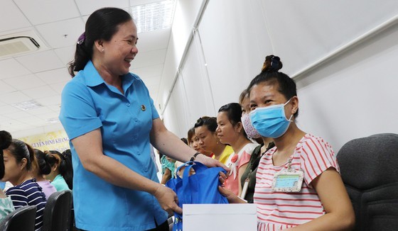 A representative of a trade union gives gift to pregnant workers (Photo:SGGP)