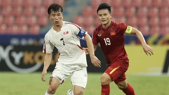 Team captains of Vietnam Nguyen Quang Hai (in red) and the DPRK Ri Chung-gyu vie for the ball (Photo: VNA)
