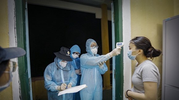 Health workers record health information of a woman at a quarantine site (Photo: VNA)