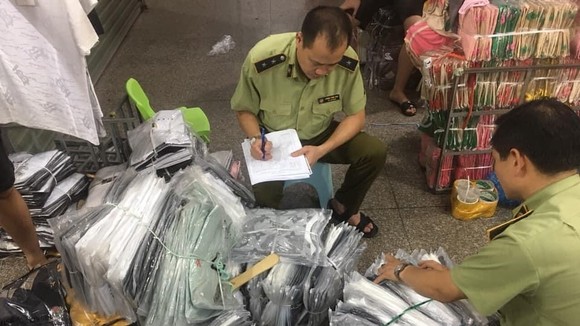 Cán bộ QLTT kiểm kê các lô hàng thời trang nhái, lậu trong chợ Ninh Hiệp hôm 4-6