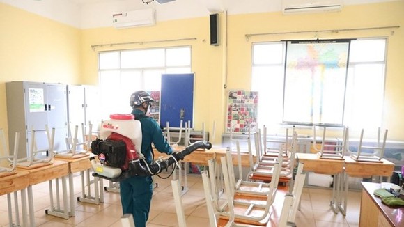 A worker sprays disinfectant at a classroom of the Viet Duc High School in Hanoi's Hoan Kiem district on February 2 (Photo: VNA)