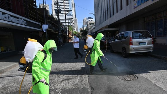 Workers disinfect an area in Manila, the Philippines, on March 19 to help curb the spread of COVID-19 (Photo: AFP/VNA)