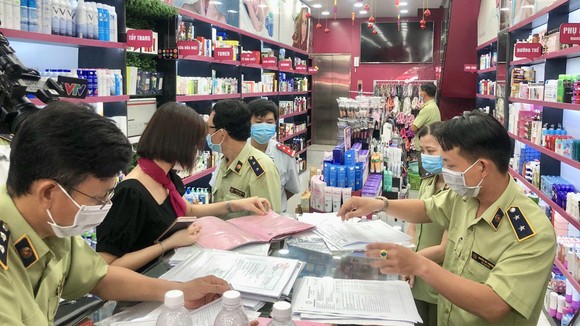 Lực lượng chuyên trách kiểm tra một cơ sở nghi kinh doanh mỹ phẩm giả mạo tại TPHCM