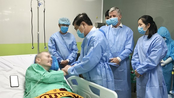 Chủ tịch UBND TPHCM Nguyễn Thành Phong thăm hỏi, động viên bệnh nhân thứ 91 – phi công người Anh tại Bệnh viện Chợ Rẫy, chiều 17-6-2020. Ảnh: HOÀNG HÙNG
