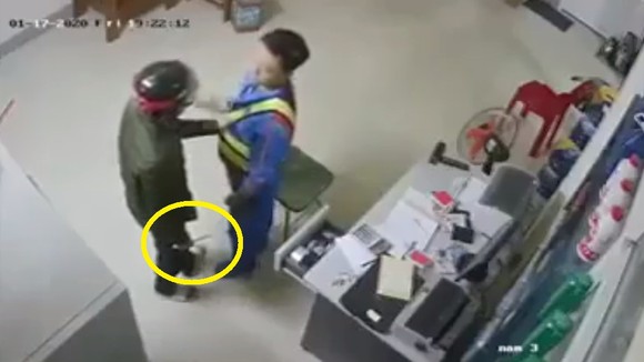 Đối tượng cầm dao khống chế nhân viên cửa hàng xăng dầu. Ảnh cắt từ clip
